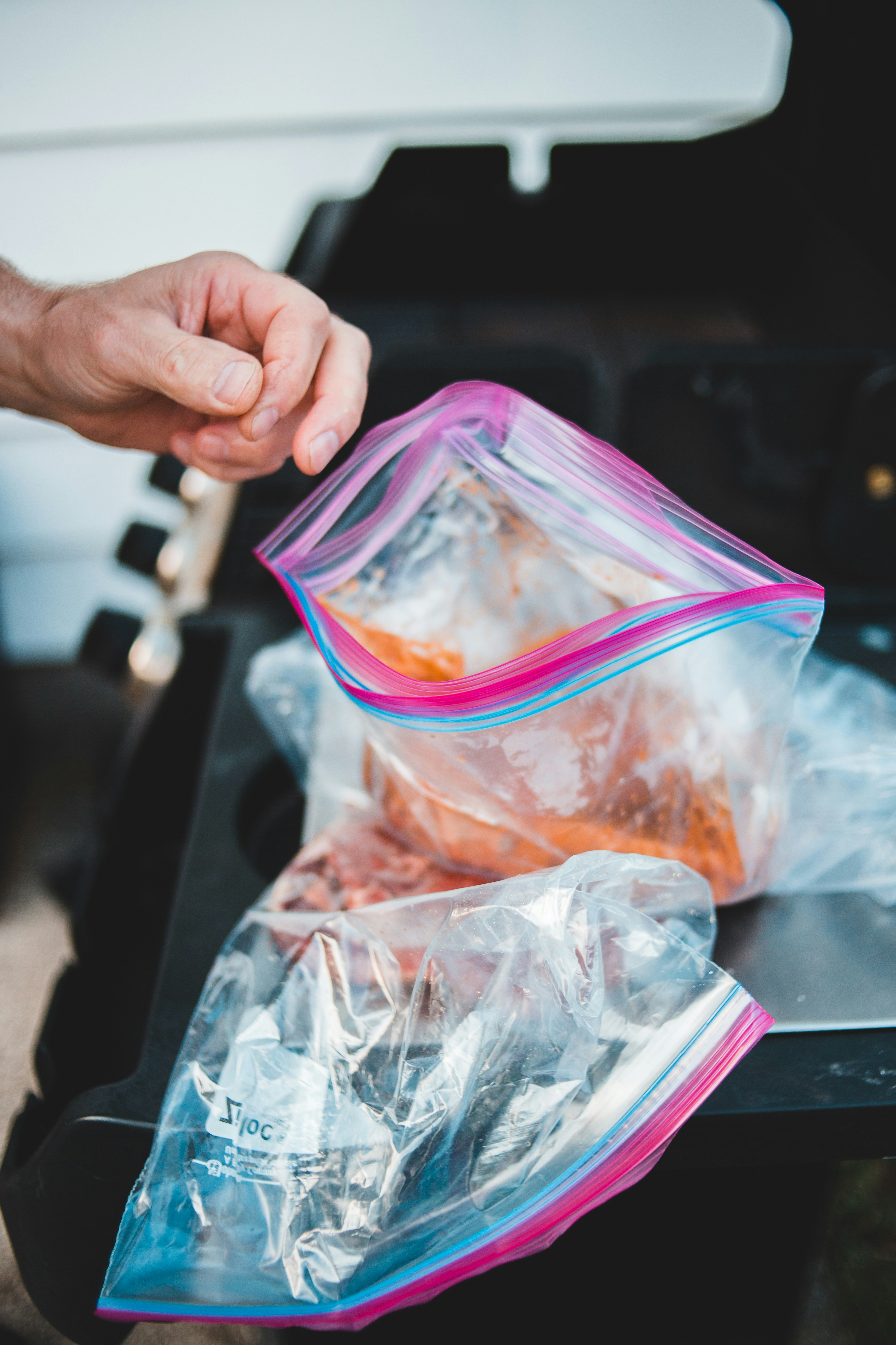 person holding pink plastic container